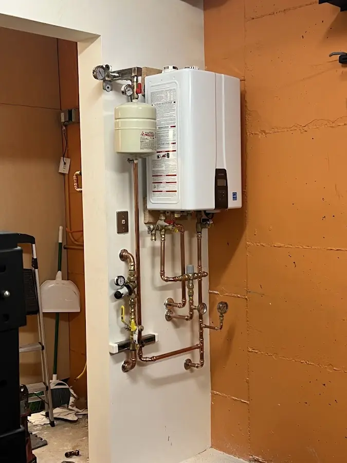 Plumbing technician inspecting water heater connections in Adelanto